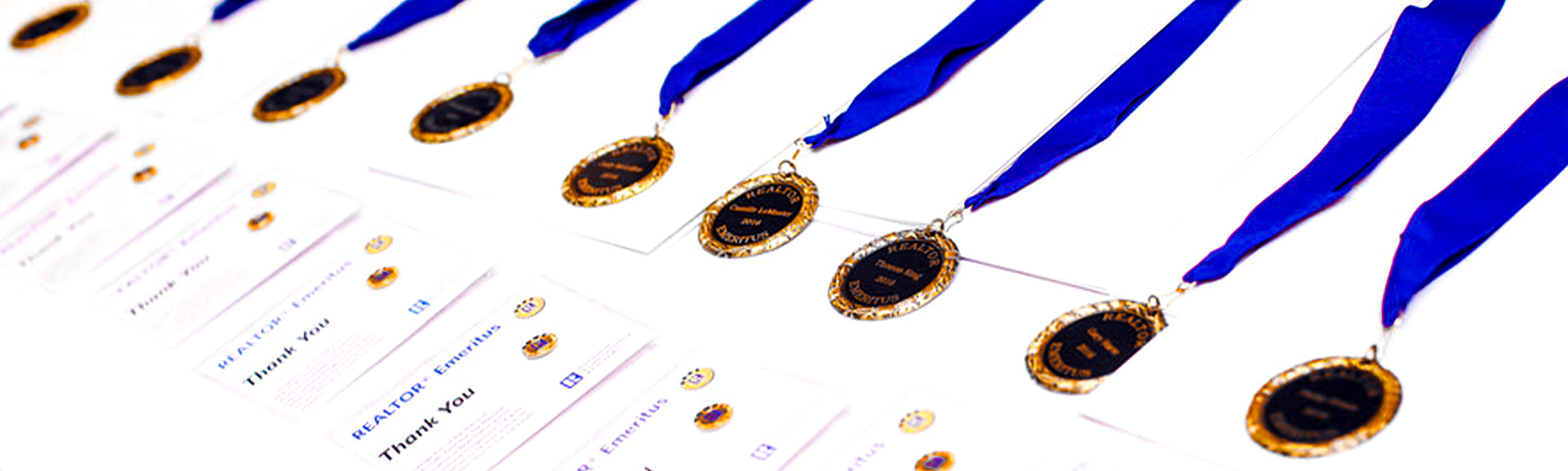 Row of REALTOR® Emeritus Medals and Badges Lined on a Table